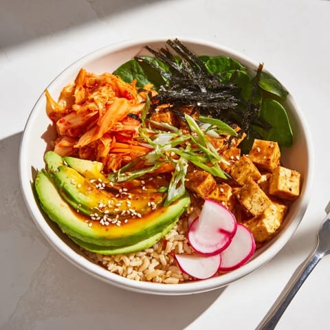 Delicious fermented vegetable bowl garnished with avocado and sesame seeds.  