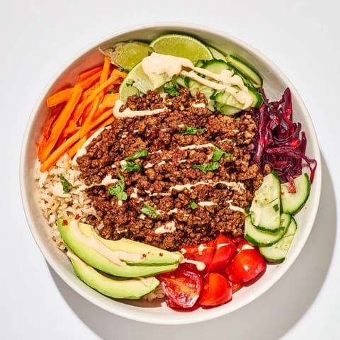 Delicious plant-based meat bowl featuring vibrant vegetables and creamy, spicy sauce.  