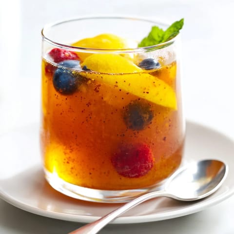 Homemade kombucha-style mocktails garnished with fresh mint and colorful berries, ready to serve.  