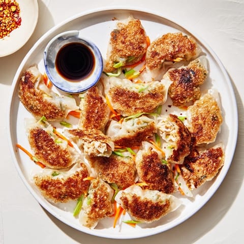 A close-up of perfectly pan-fried crispy rice paper dumplings, ready to be enjoyed with tasty sauce.