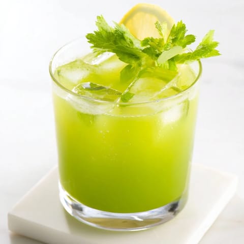 Celery Ginger Lemon Juice in a clear pitcher with crisp celery stalks and lemon slices, showcasing the bright, nourishing blend ready to be poured.