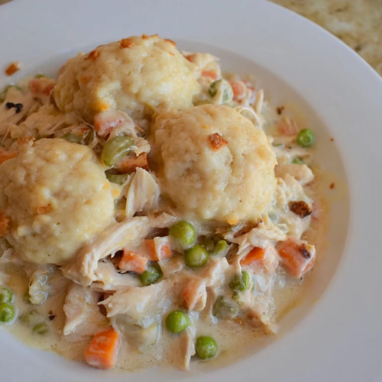 Golden-brown Chicken and Dumplings Casserole bubbling in a baking dish, ready to be served hot.