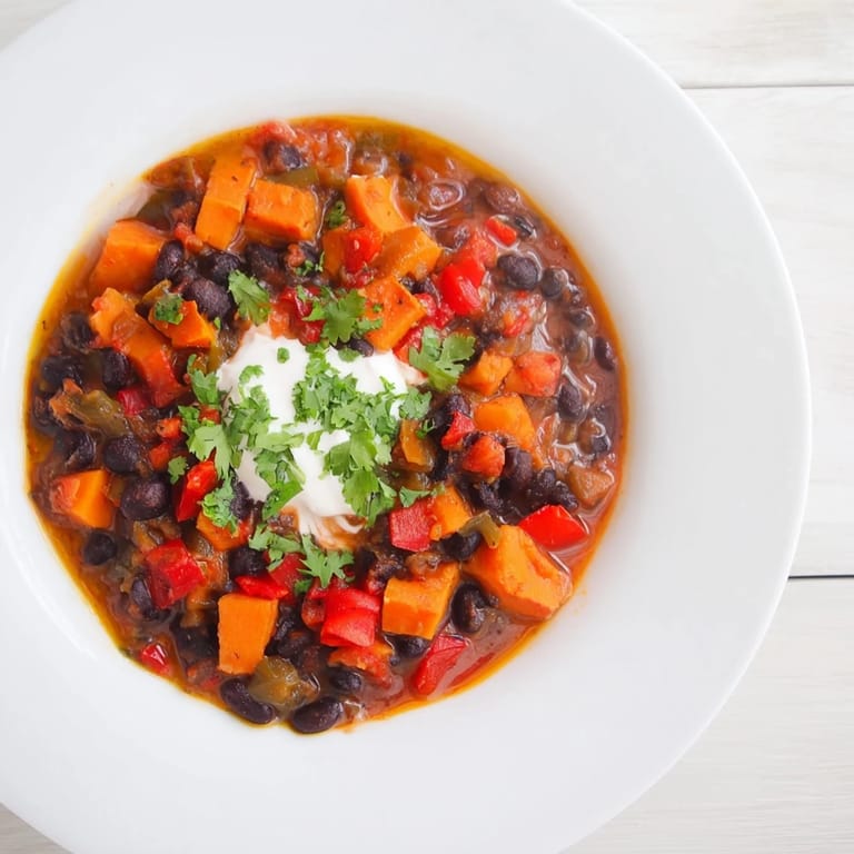 Homemade Sweet Potato & Black Bean Chili simmering in a pot, ready for serving and enjoying.