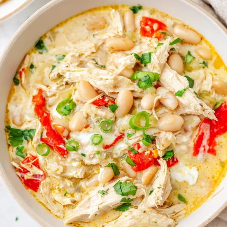 Close-up of a flavorful creamy white chicken chili with beans, showcasing its rich texture and spices.