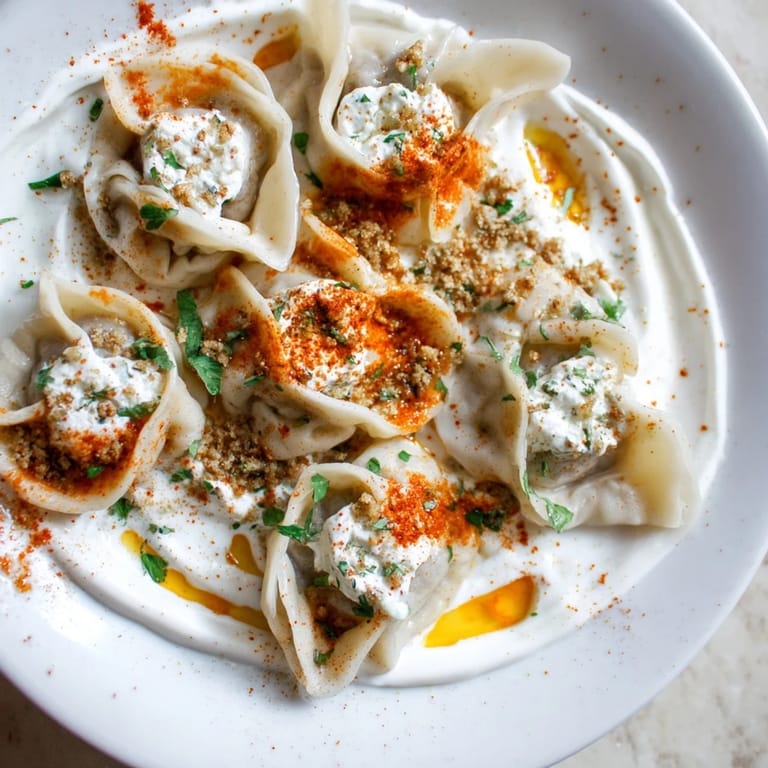 Close-up of Turkish cheesy manti, filled with melty cheese, ready to be enjoyed with flavorful toppings.